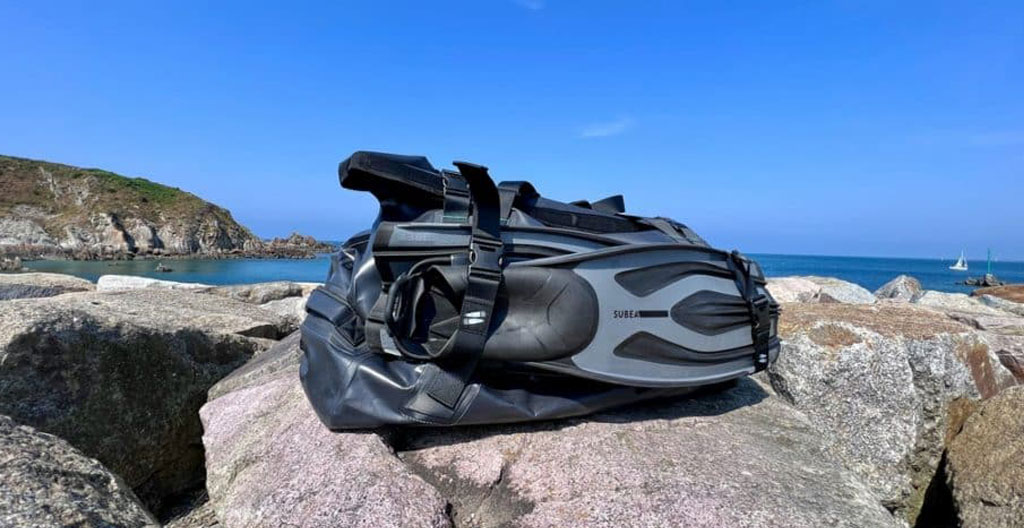 Sac de plongée 45L surchargé avec équipement débordant, illustrant les conséquences d'un mauvais dimensionnement
